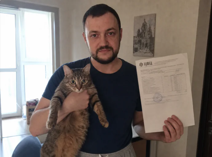 Хозяин с котом и результатами анализов после выезда ветеринара